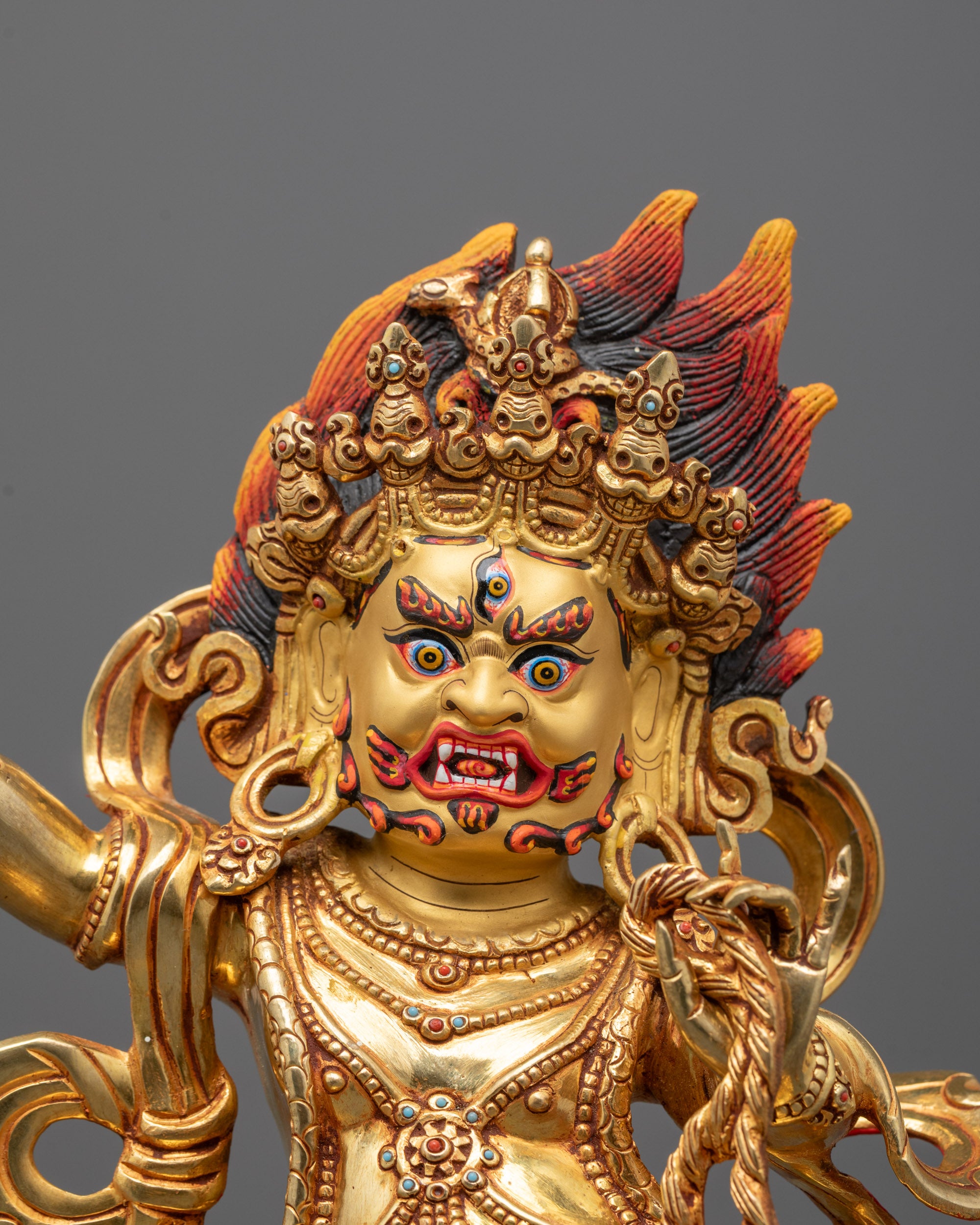 Close-up of Vajrapani Statue showing five-skull crown and serpent mala details