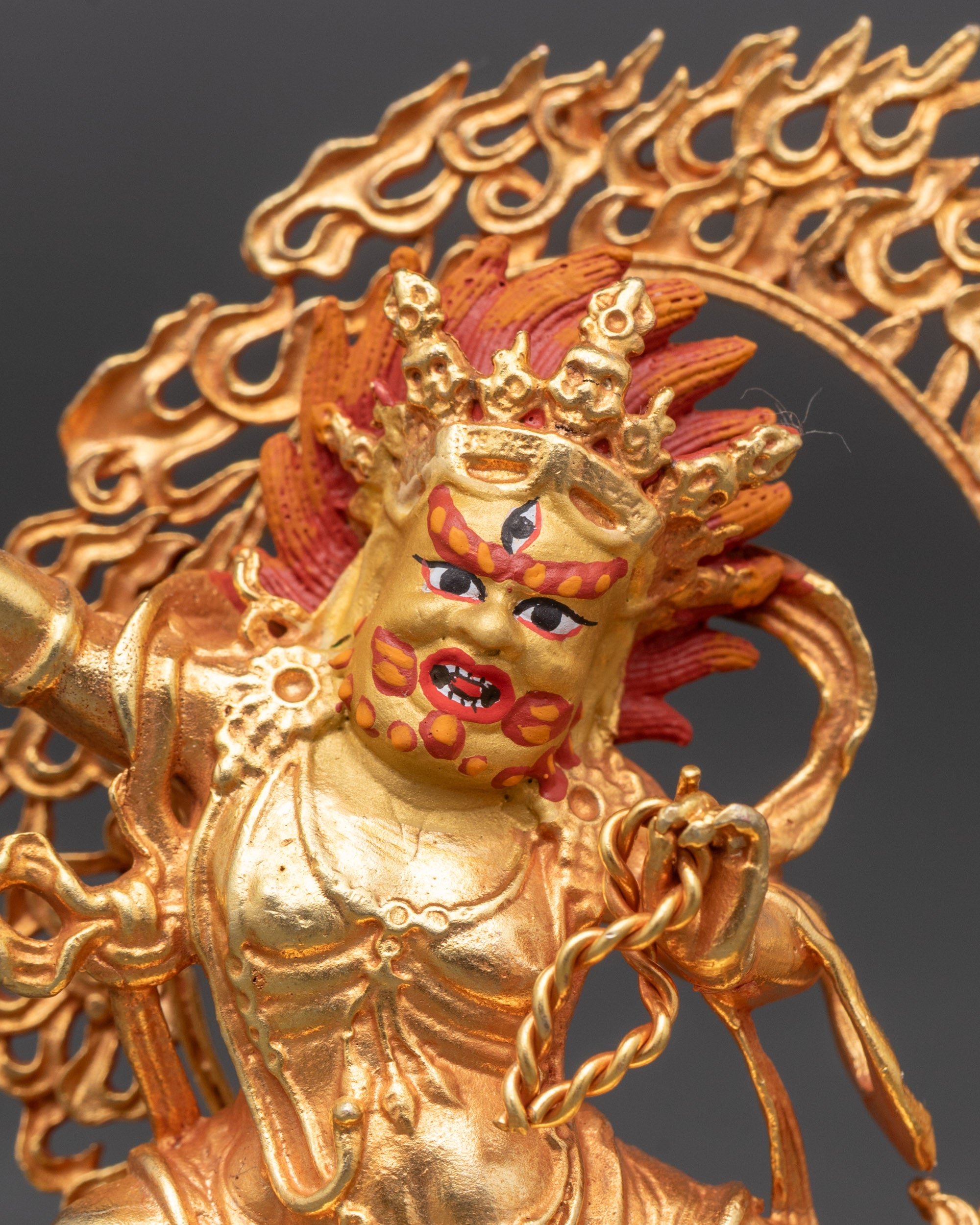 Close-up of Vajrapani statue’s blazing halo and intricate gold-painted facial details