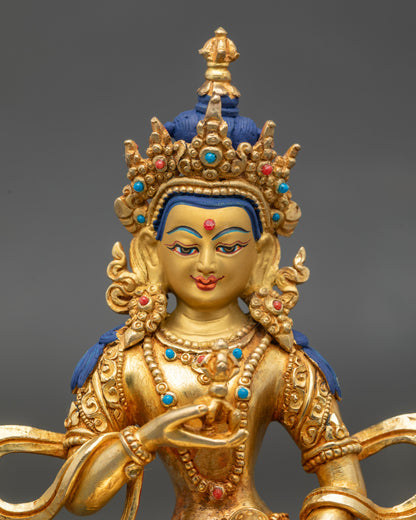 Close-up of Vajrasattva Buddha face with serene gold-painted expression and gilded details
