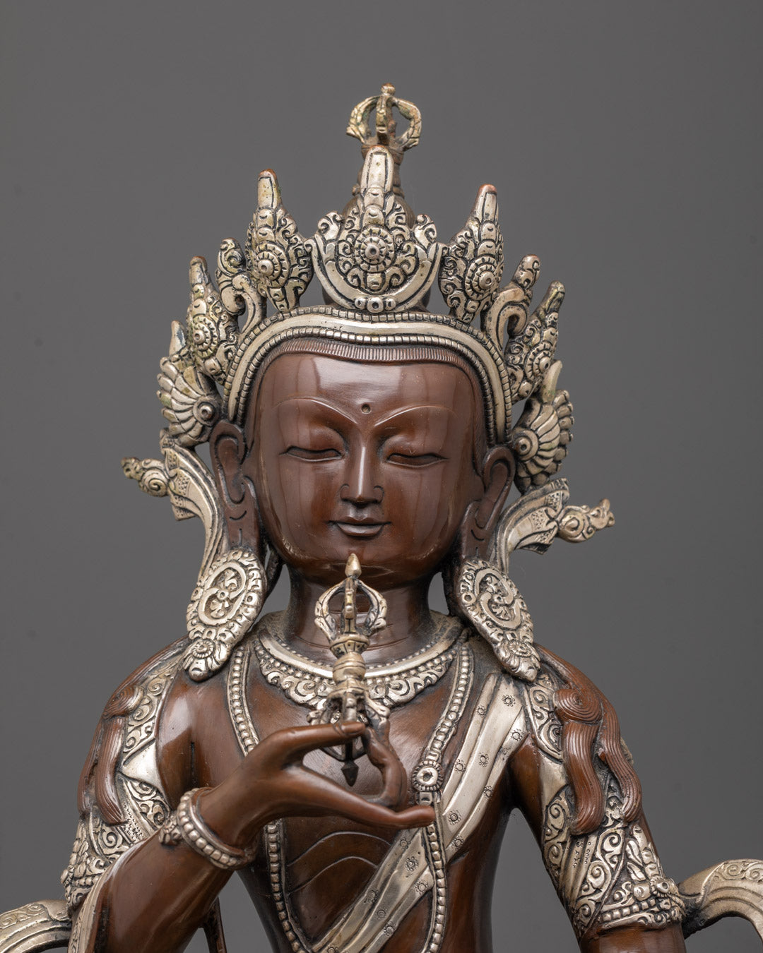 Close-up of Vajrasattva Statue’s serene face and vajra ornament, highlighting fine details