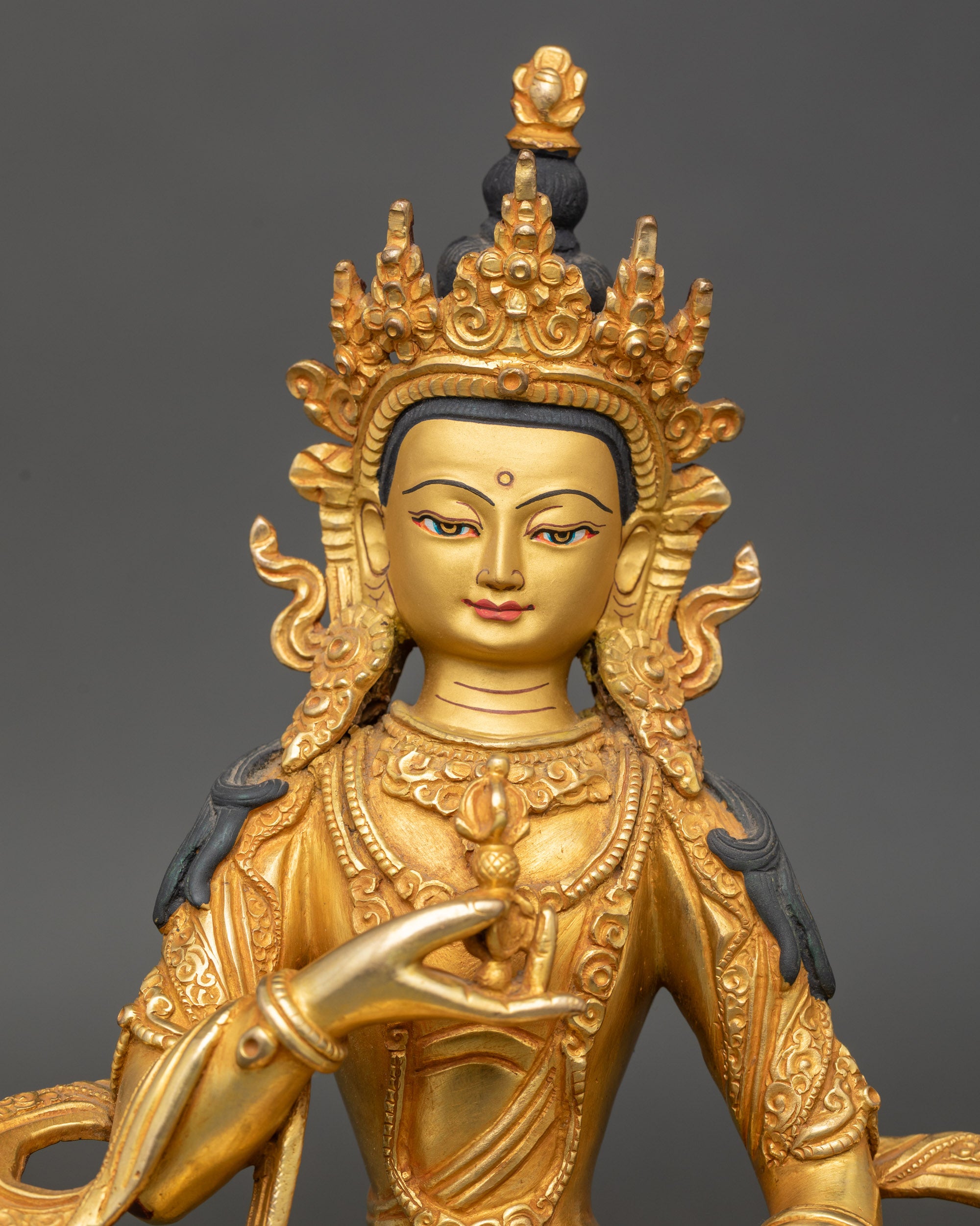 Close-up of Vajrasattva face, 24K gold-painted, detailed Newari craftsmanship
