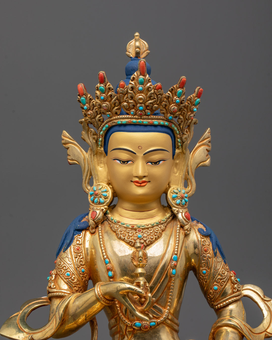 Close-up of Vajrasattva holding vajra and bell, adorned with semi-precious stones