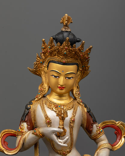 Close-up of Vajrasattva holding vajra and bell in meditation pose with semi-precious stone