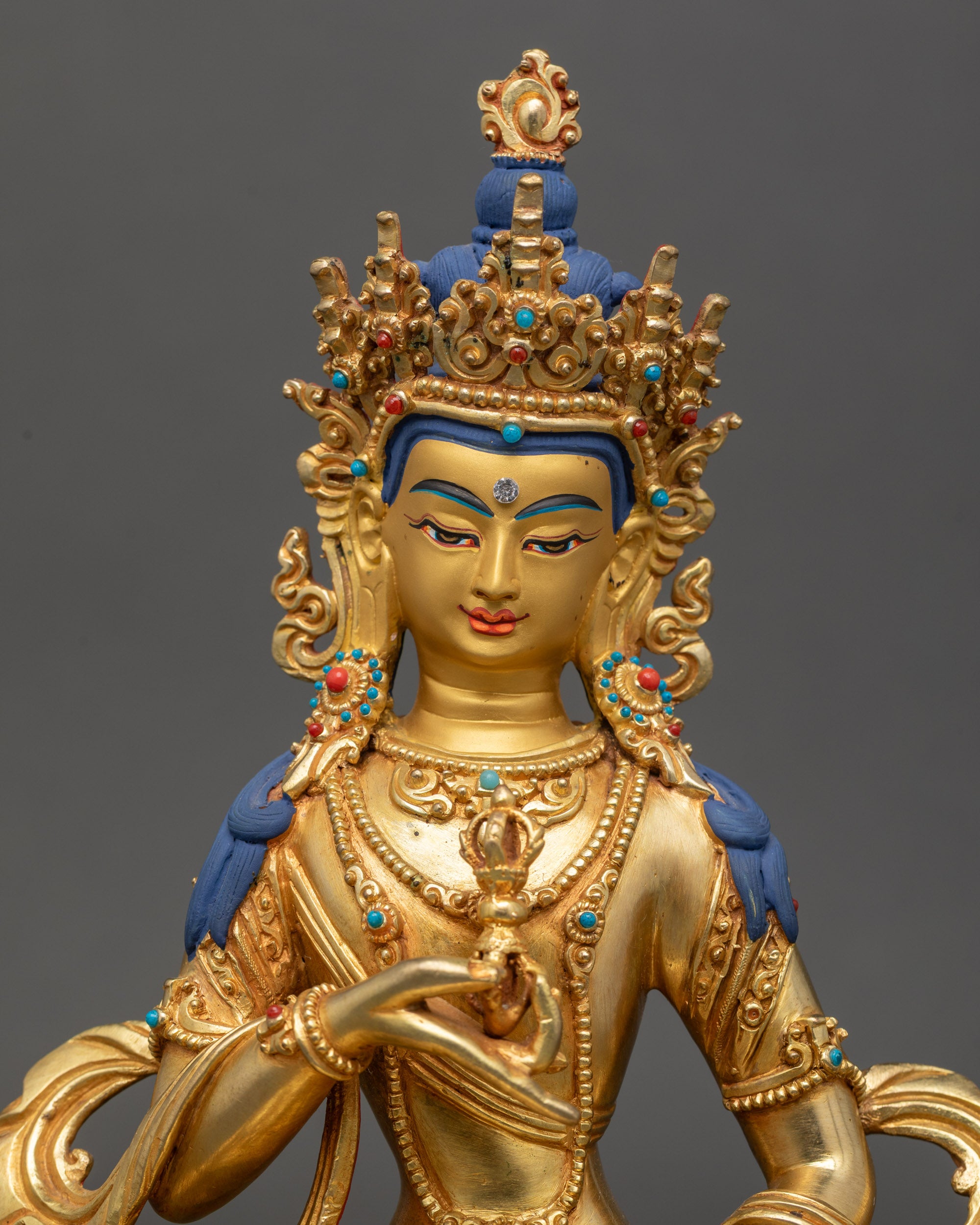 Close-up of Vajrasattva statue face, 24K gold-painted, detailed Newari craftsmanship