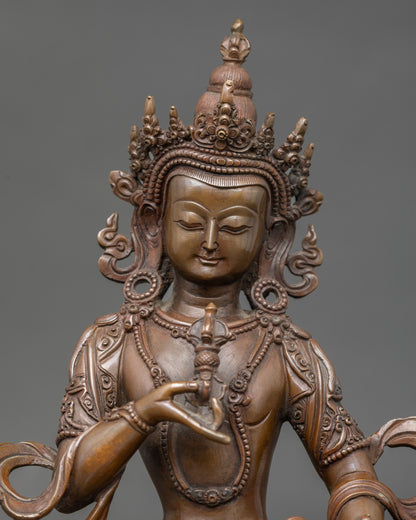 Close-up of Vajrasattva statue face showing serene expression and oxidized copper details
