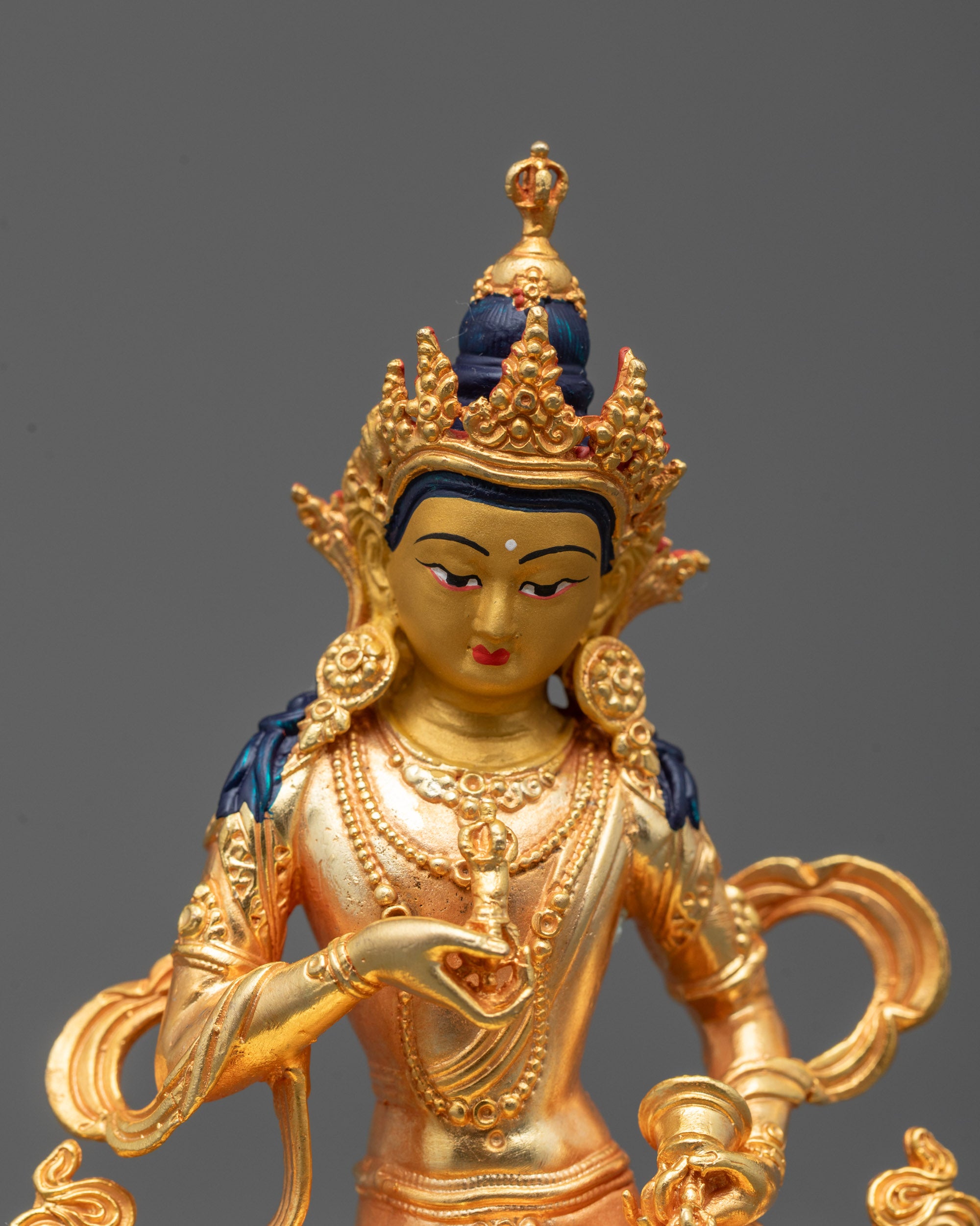 Close-up of Vajrasattva statue face with 24k gold coating and five-jeweled crown details