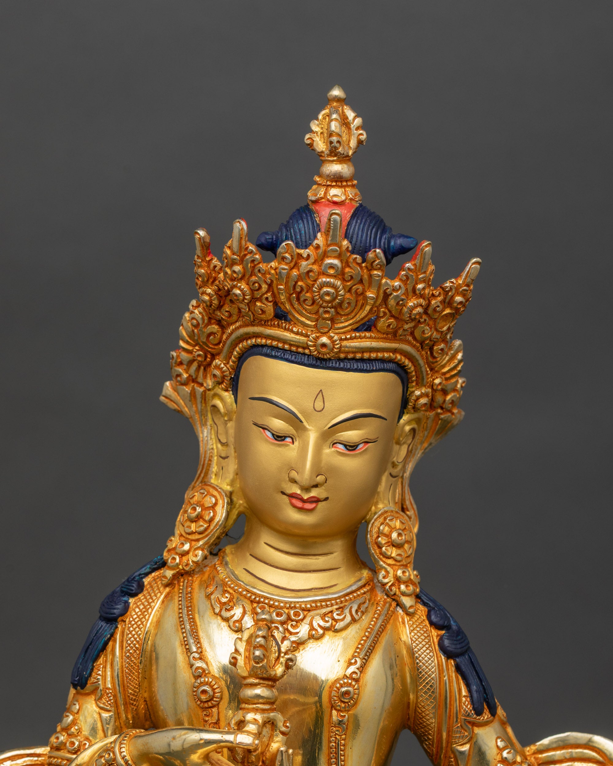 Close-up of Vajrasattva statue showing serene expression and intricate gold-gilded details