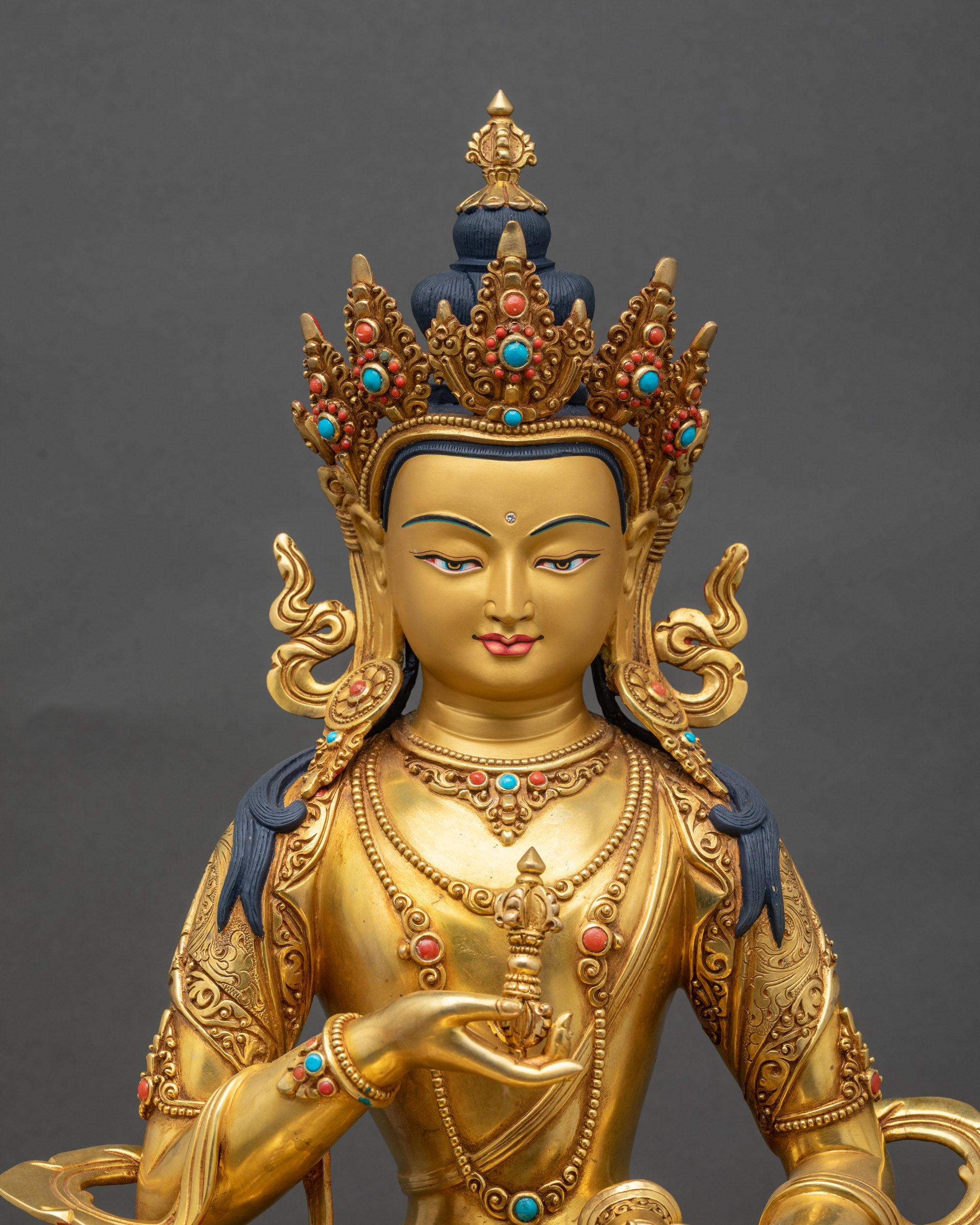 Close-up of Vajrasattva statue showing vajra and bell, gold gilded copper sculpture