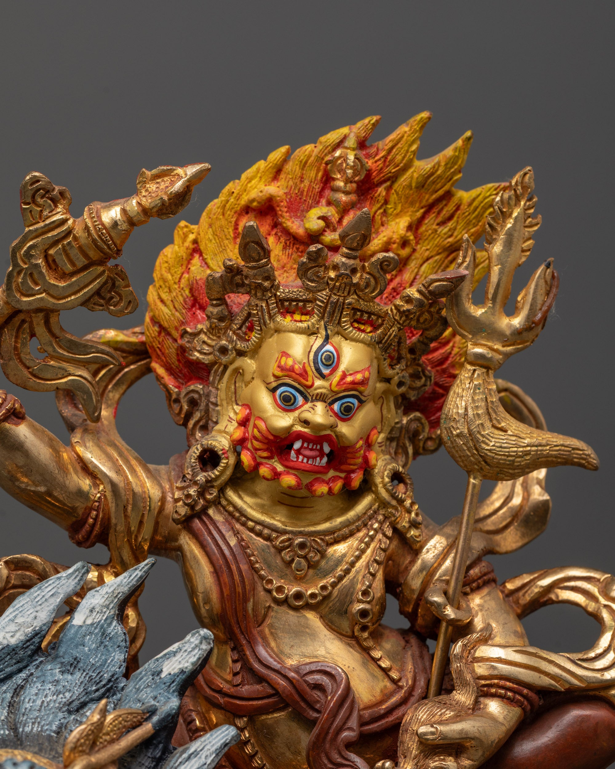 Close-up of White Dzambhala’s wrathful face showing intricate 24k gold gilding