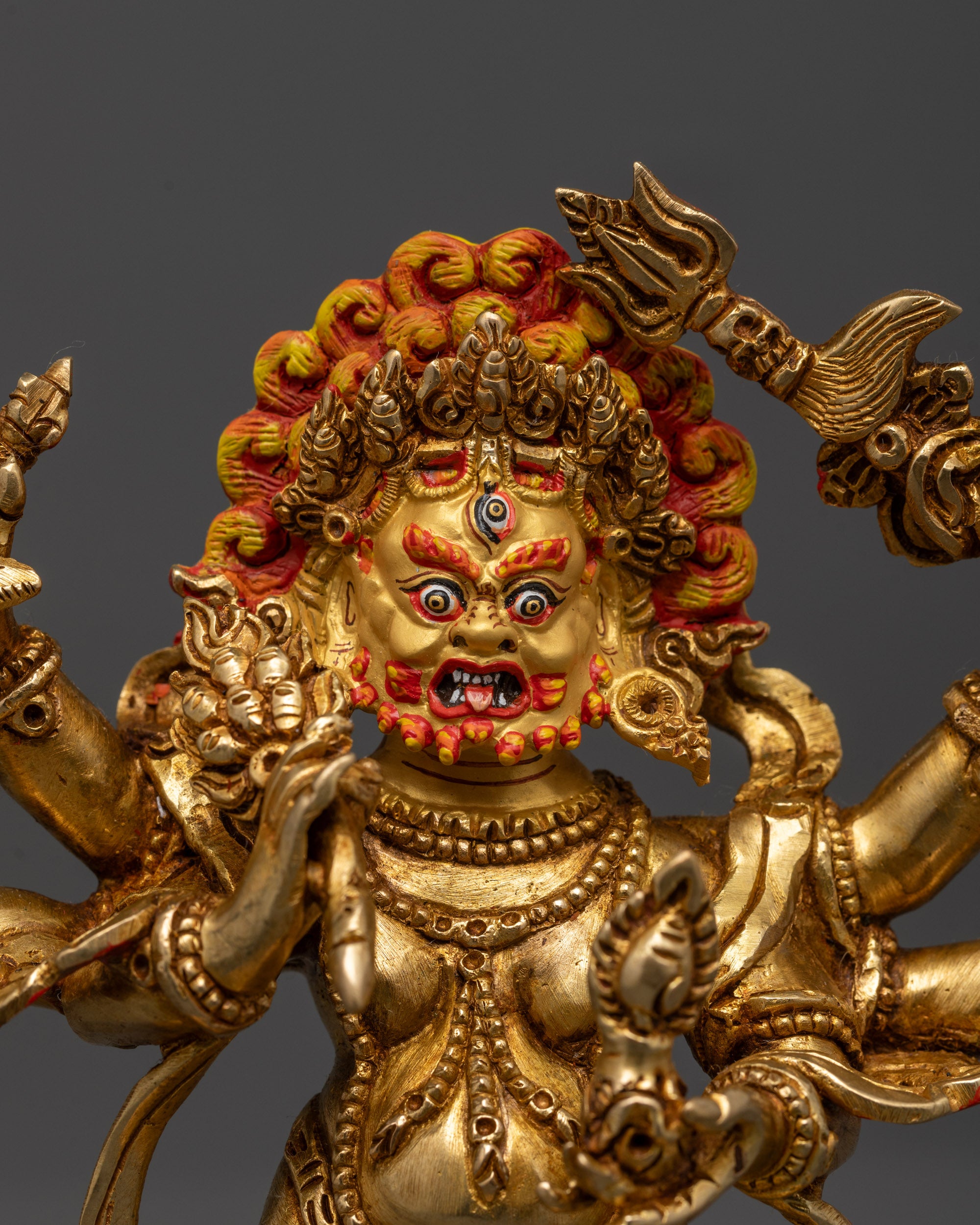 Close-up of White Mahakala’s fierce face with radiant gold finish and intricately carved crown
