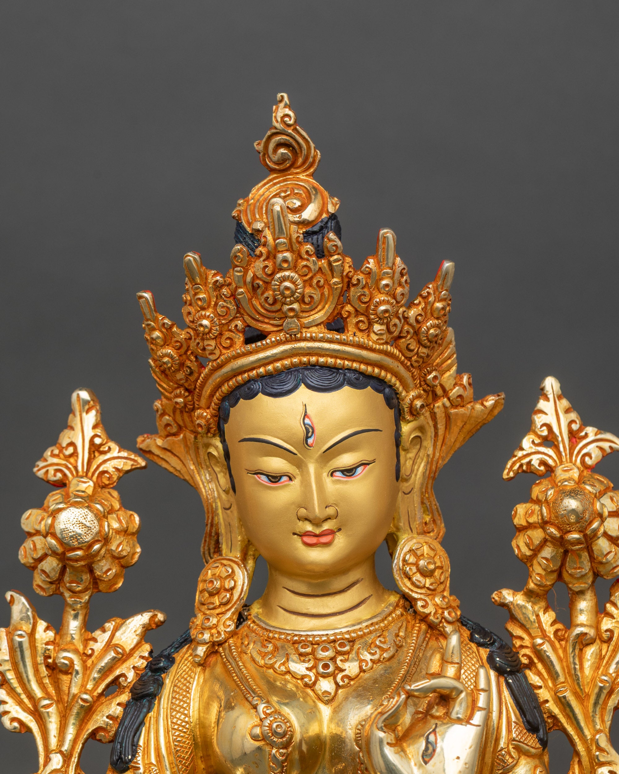 Close-up of White Tara deity statue showing seven eyes and intricate lotus posture details