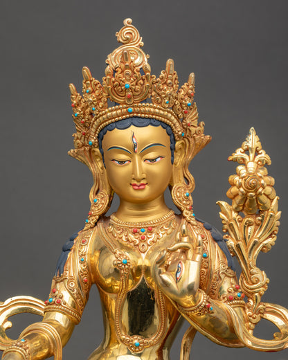 Close-up of White Tara face with gold paint and serene compassionate expression