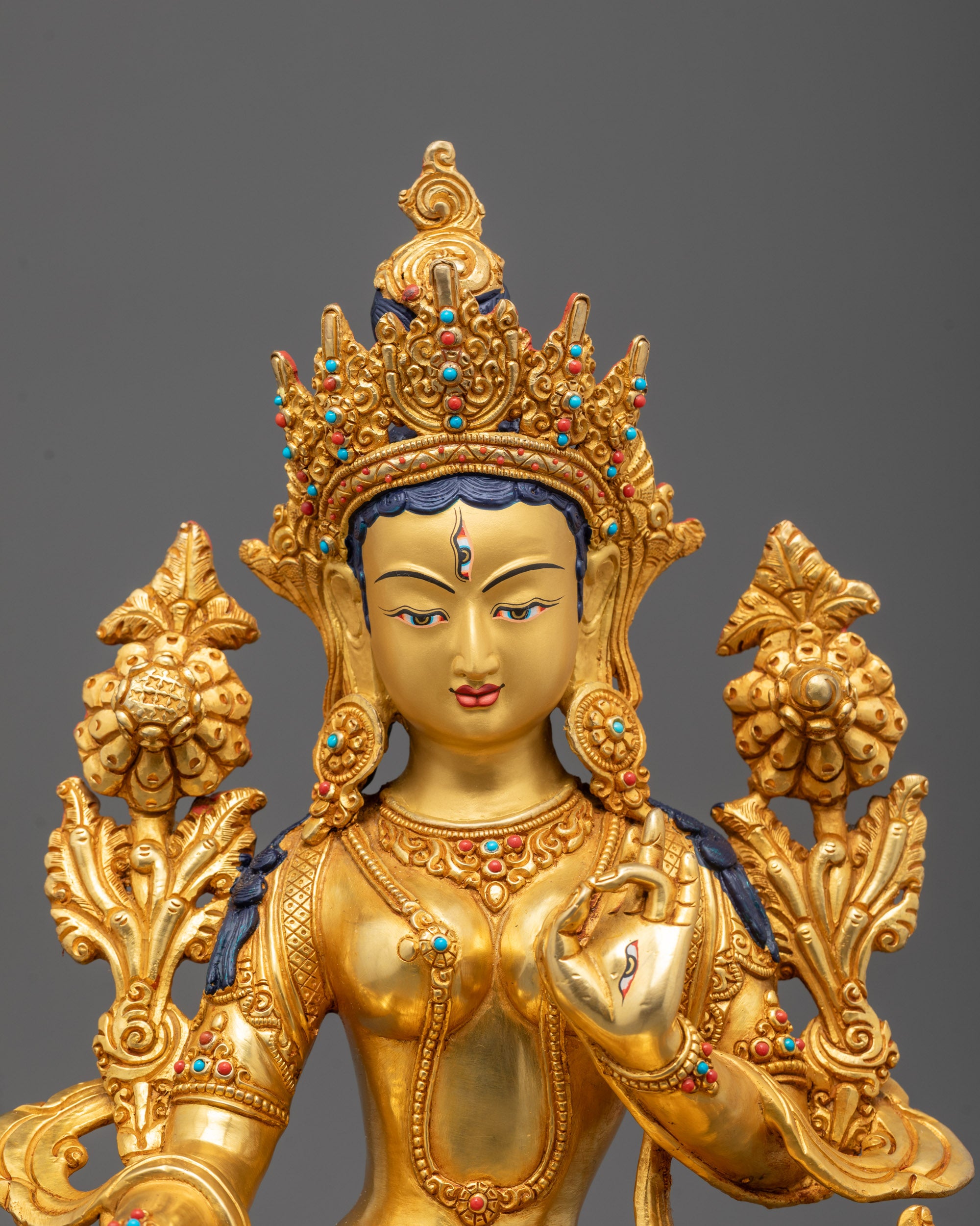 Close-up of White Tara’s serene face adorned with 24k gold