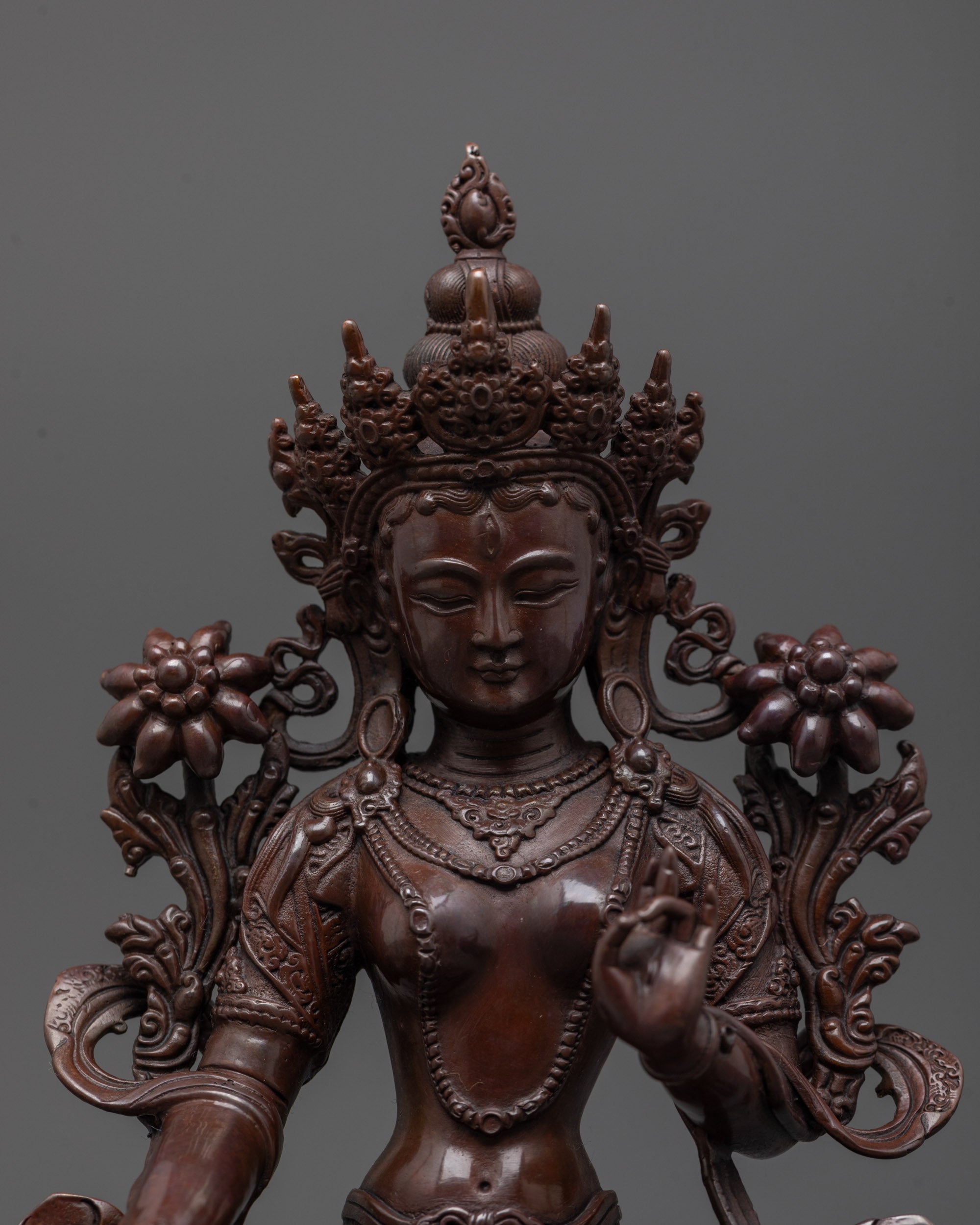 Close-up of White Tara statue’s oxidized copper finish, showing seven eyes and fine details