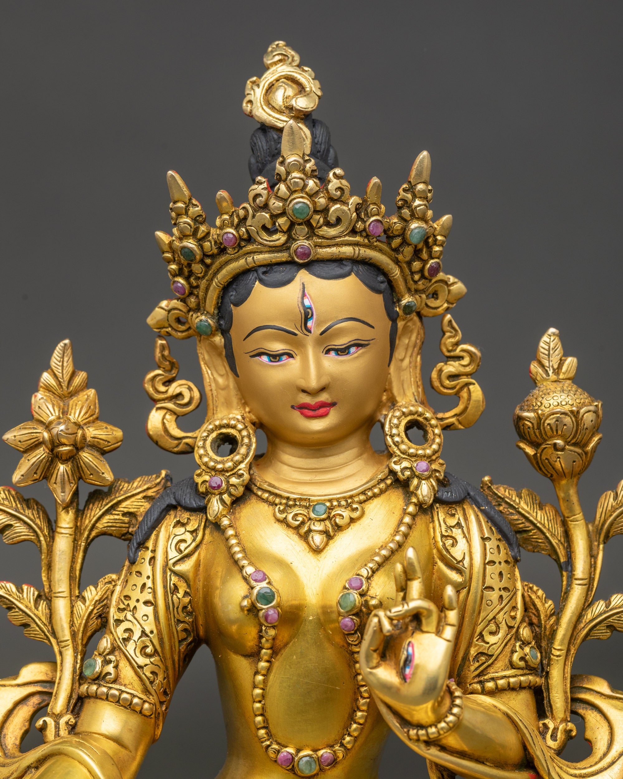 Close-up of White Tara statue showing intricate gold and semi-precious stone details, sacred Nepalese craftsmanship