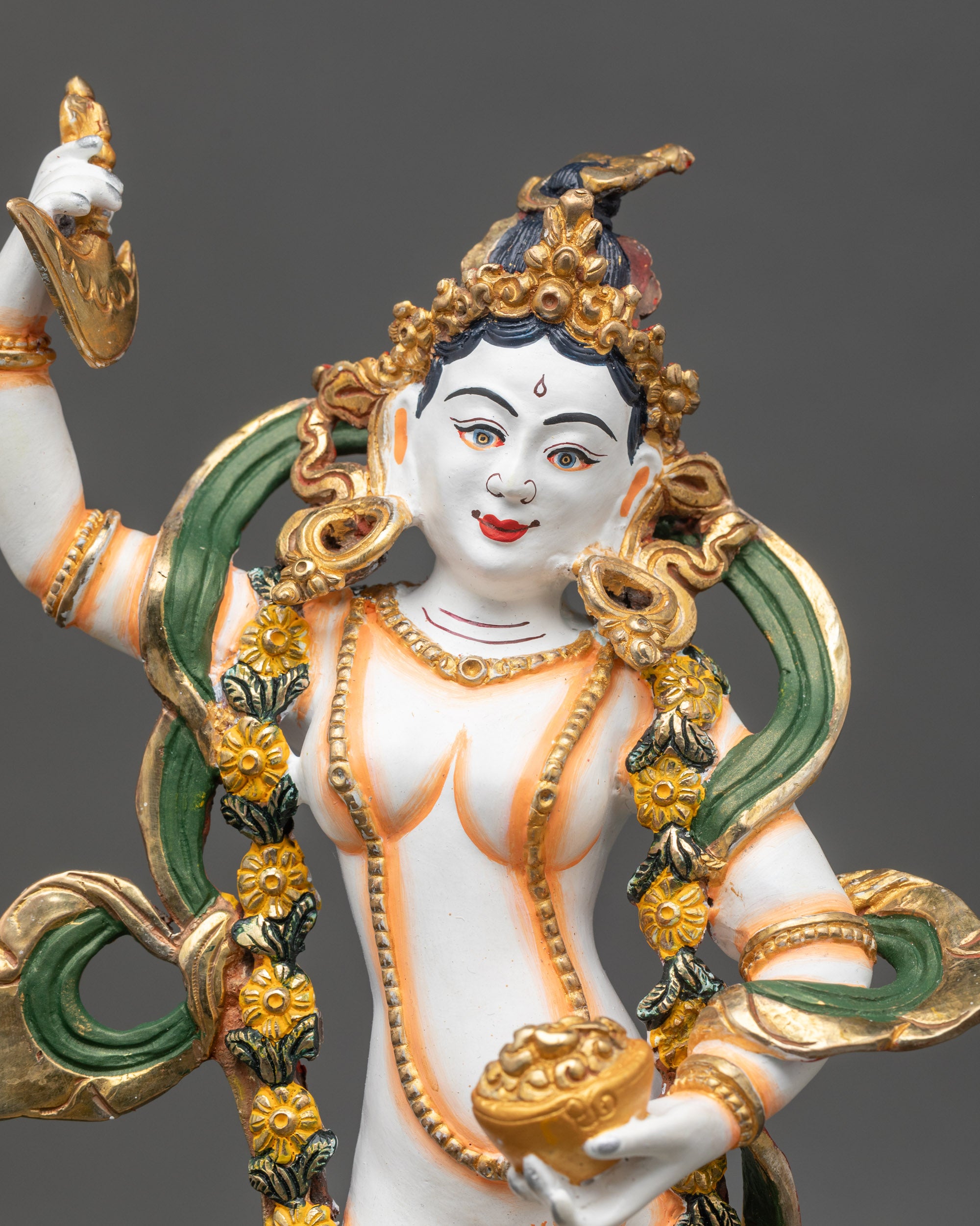 Close-up of Yeshe Tsogyal face, gold-plated highlights with white-painted body details