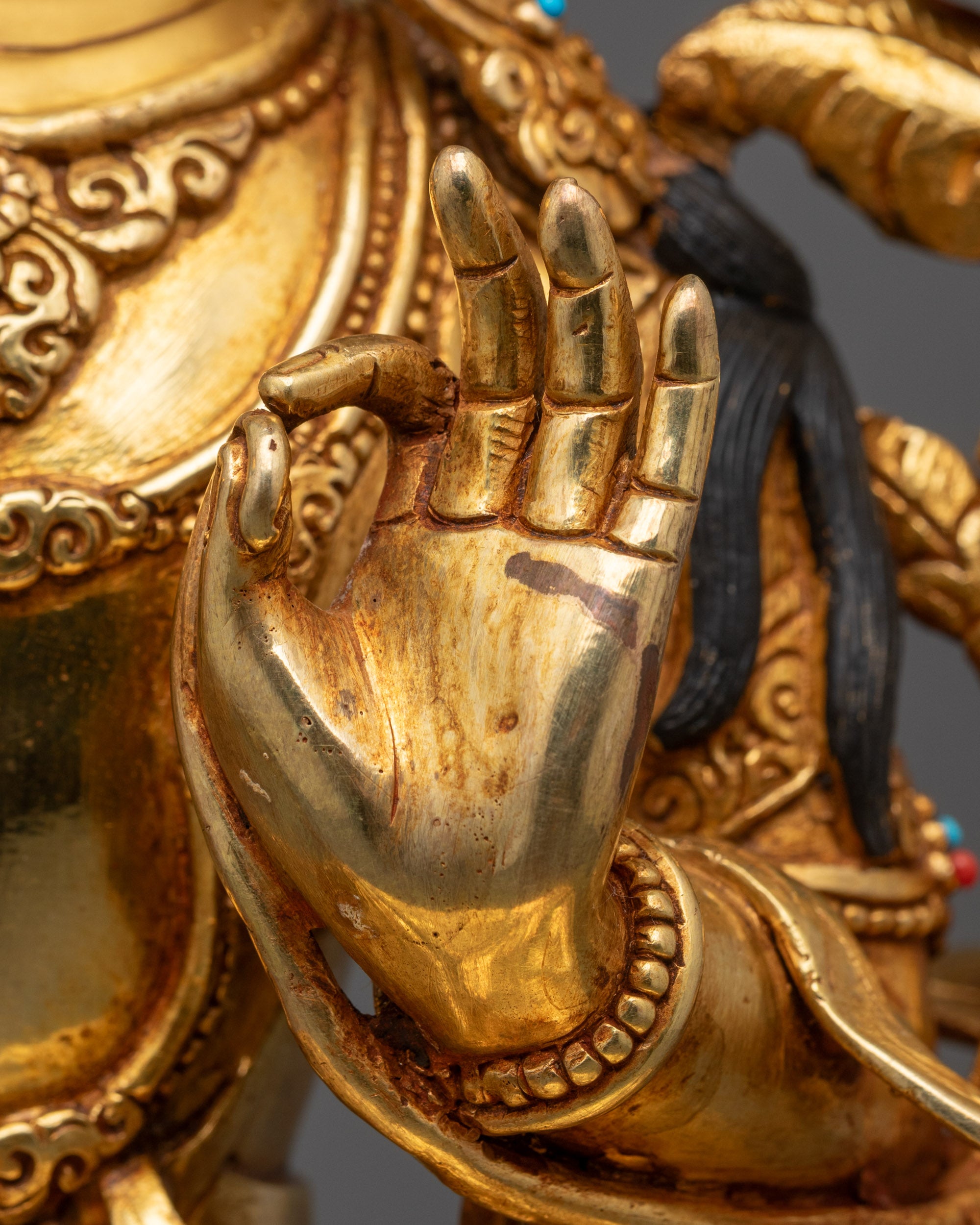 Close-up of a gold statue with detailed hand and arm