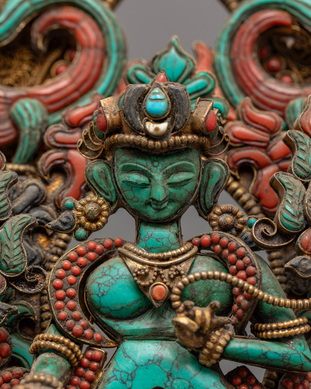 detailed Green Tara Buddha statue showing vibrant multi-colored acrylic paint and intricate stone inlay