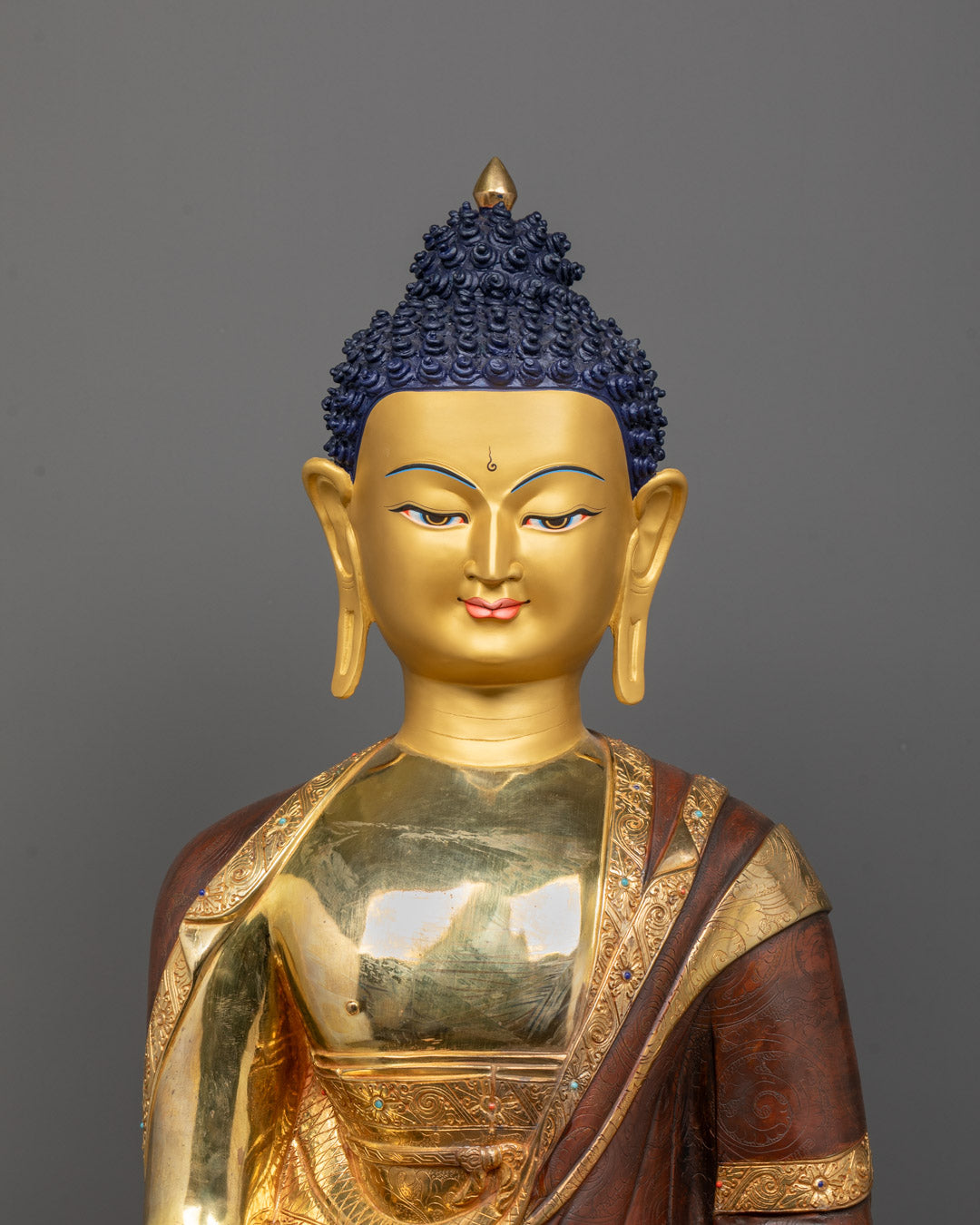 Close-up of detailed carvings on robe and alms bowl of handcrafted Shakyamuni Buddha statue
