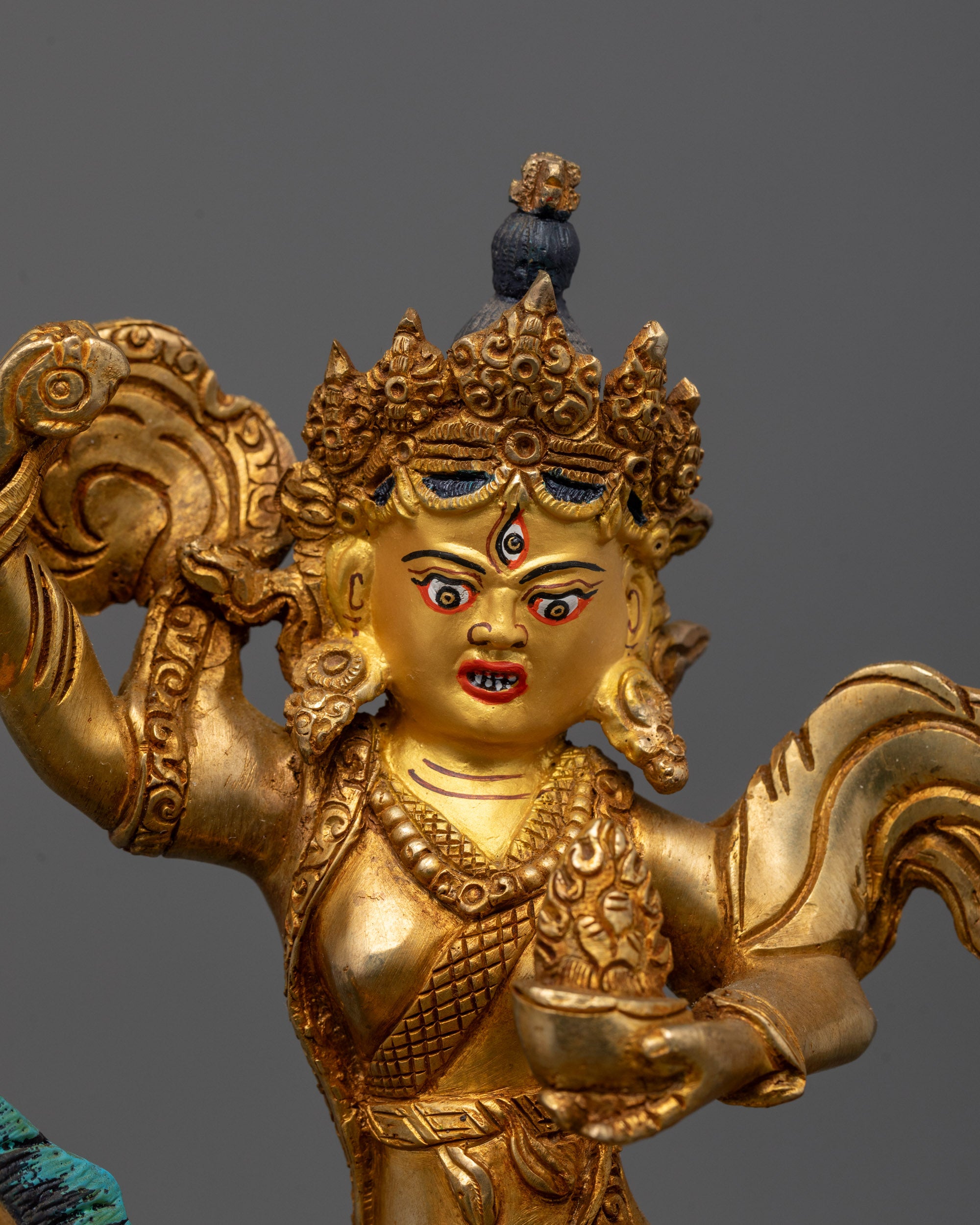 Close-up of fierce three-eyed Achi Chokyi Drolma holding damaru and sacred ritual item