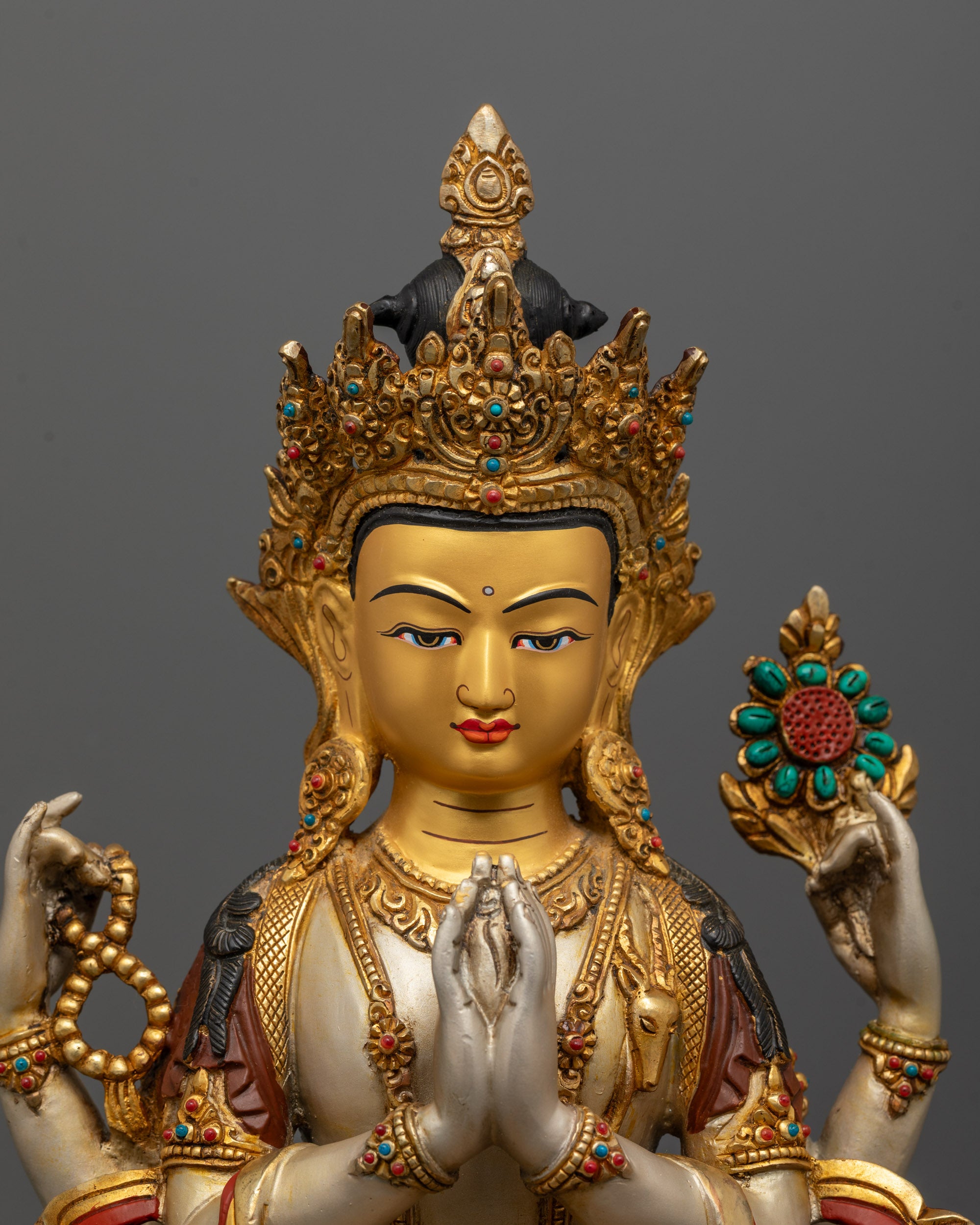 Close-up of four-armed Chenrezig Bodhisattva holding symbolic objects