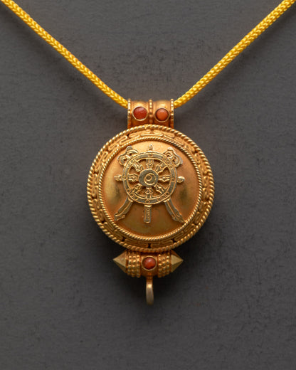 Close-up of gold-gilded Khorlo locket showing intricate carvings and stone details