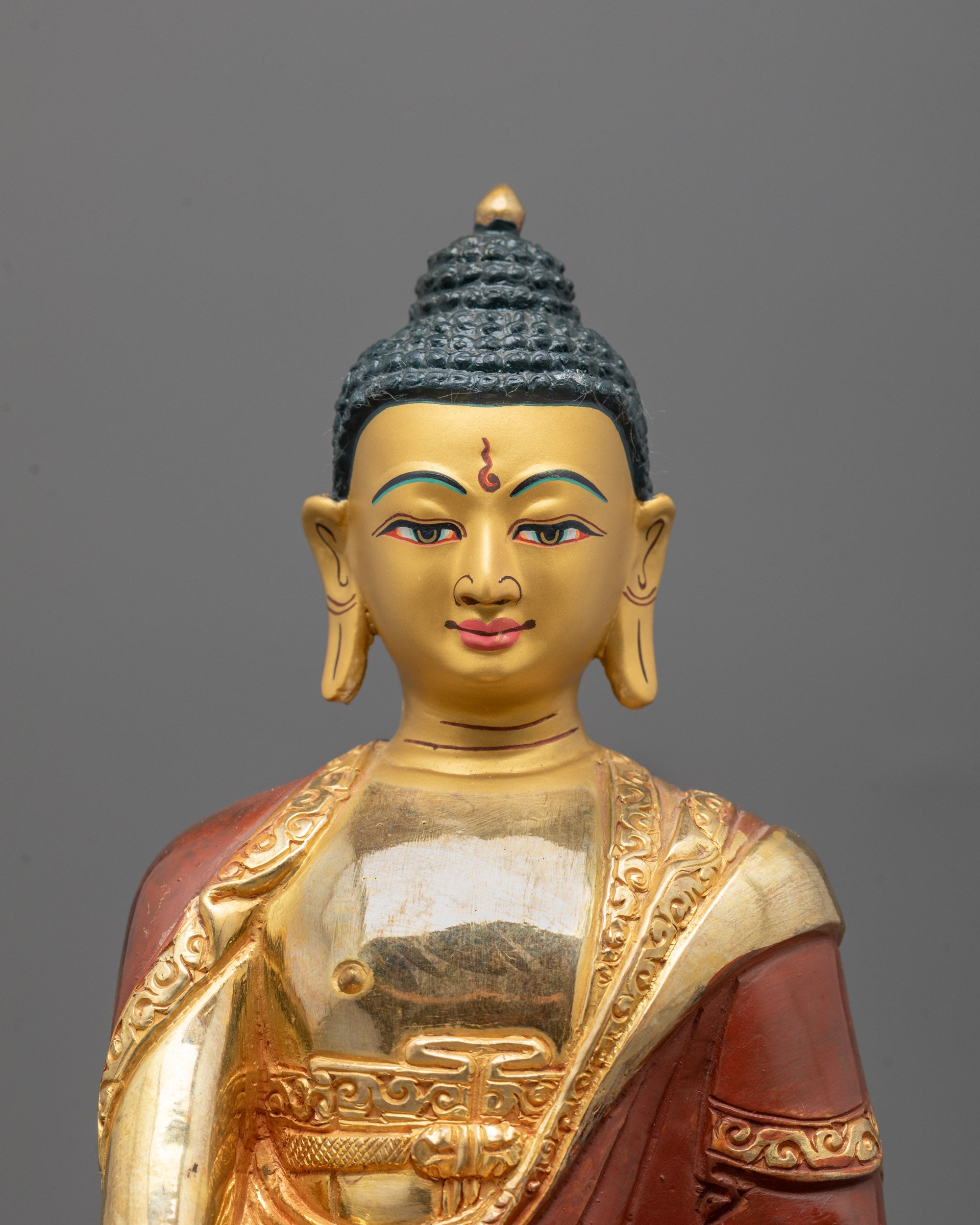 Close-up of gold-gilded face and intricate craftsmanship on Shakyamuni Buddha Statue