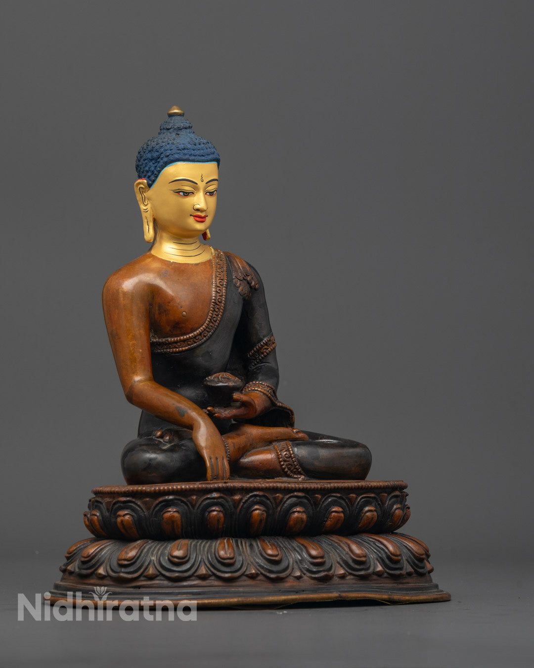 Close-up of gold-gilded face on Shakyamuni Buddha sculpture showing fine lost wax details

