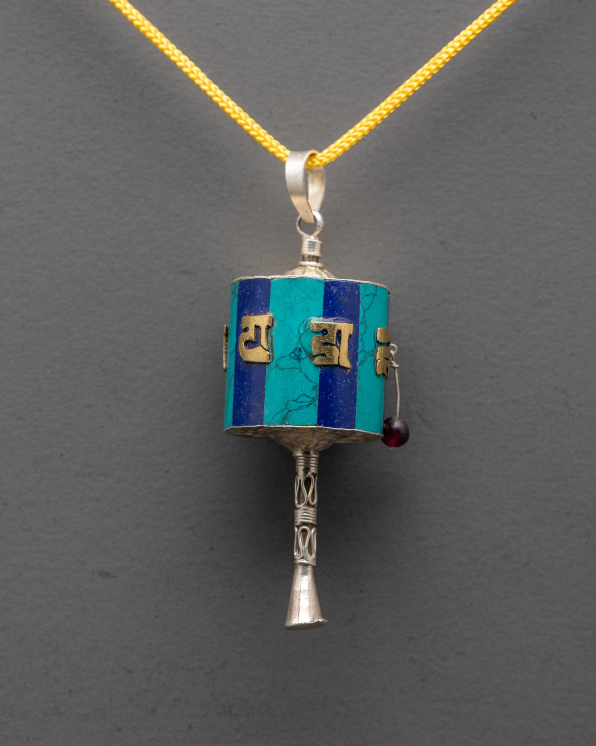 Close-up of gold-plated mantra detail on Prayer Wheel Locket crafted by Nepal artisans