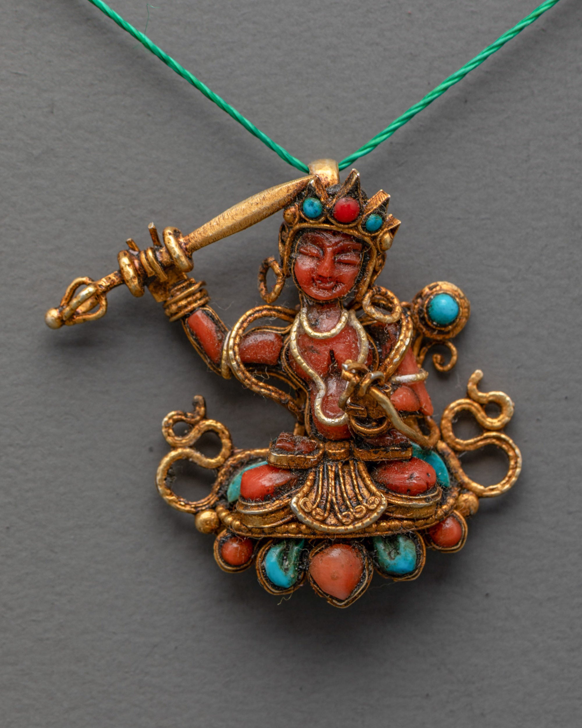 Close-up of gold filigree design on Tibetan Coral Manjushri wisdom pendant