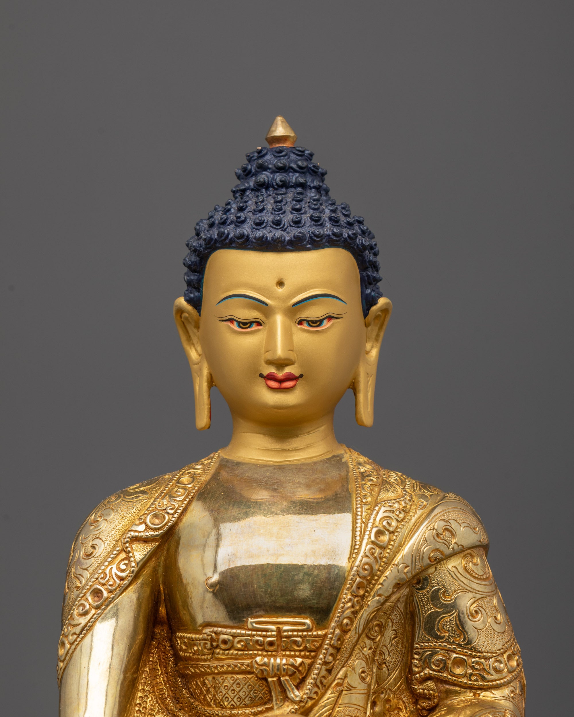Close-up of gold fire-gilded body and intricate hand-carved details on Buddha statue