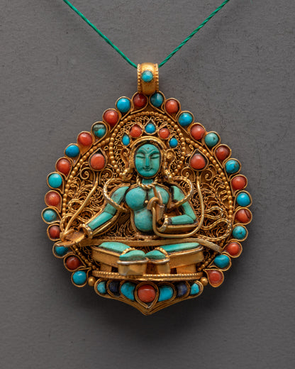 Close-up of hand-carved Green Tara centerpiece on gold-gilded locket with semi-precious stones