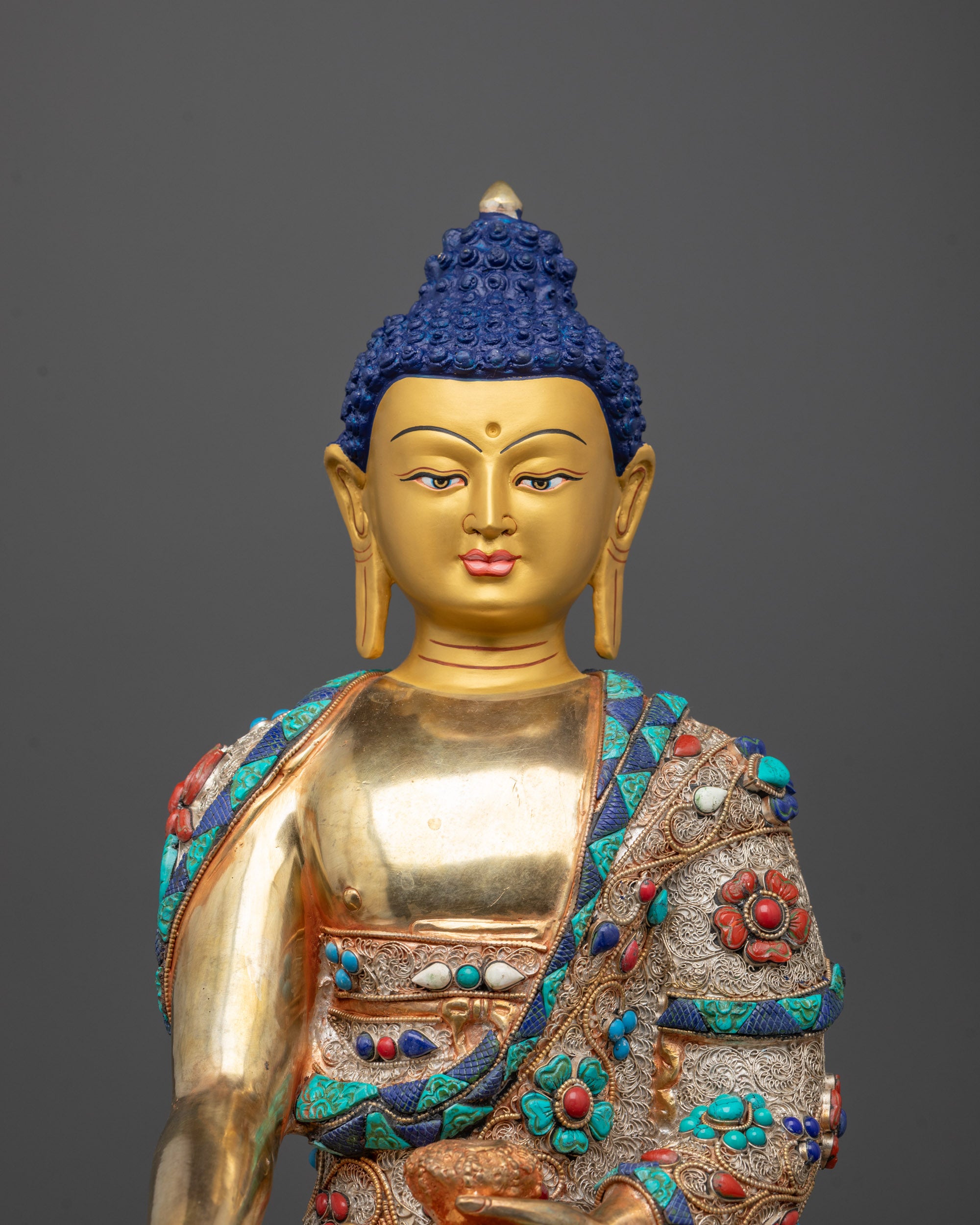 Close-up of hand-carved Shakyamuni Buddha Statue showing intricate filigree design