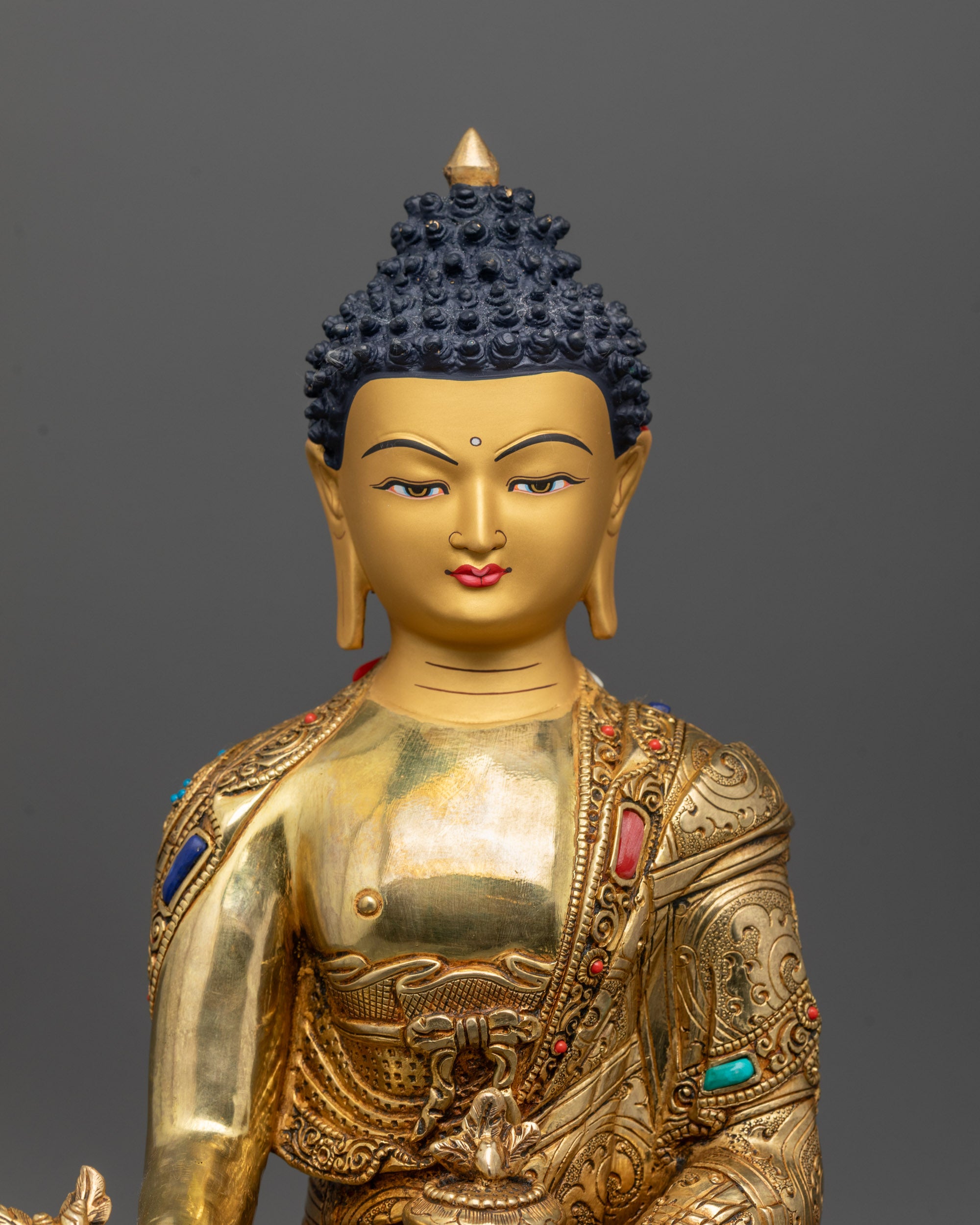 Close-up of hand-carved robe and semi-precious stones on Medicine Buddha Statue
