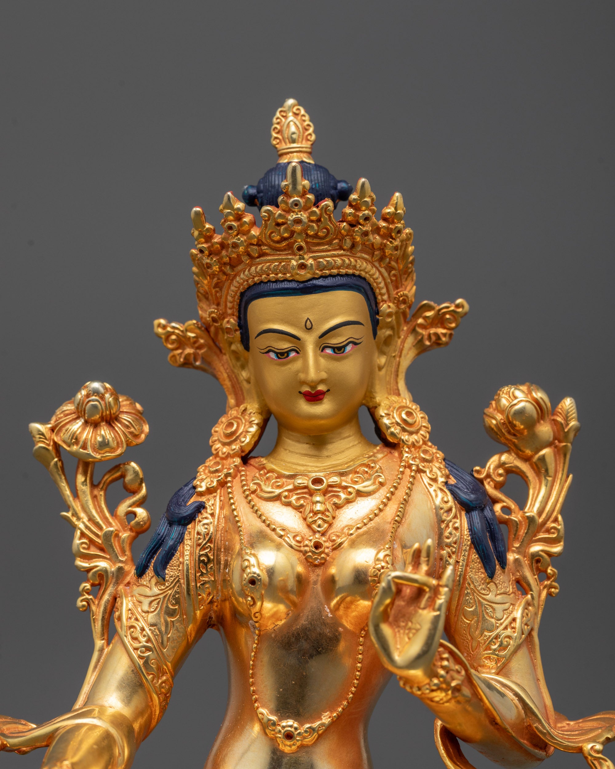 Close-up of hand and face details on Green Tara Statue showcasing the varada mudra