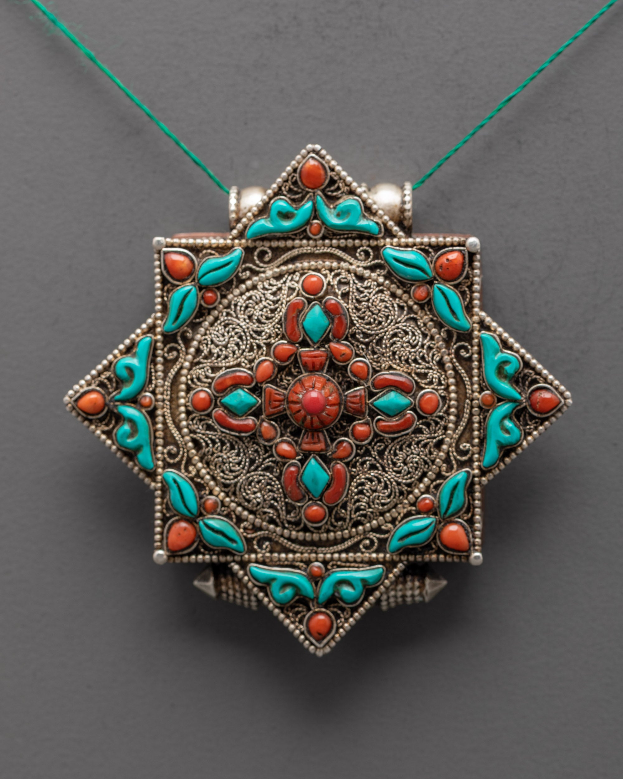 Close-up of handcrafted Bishwo Vajra Locket with silver filigree design