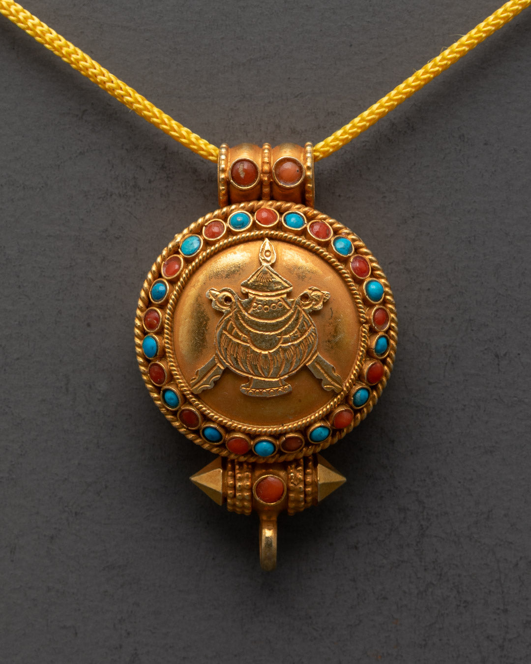 Close-up of intricate carvings on the gold-gilded Tibetan Treasure Vase Locket pendant