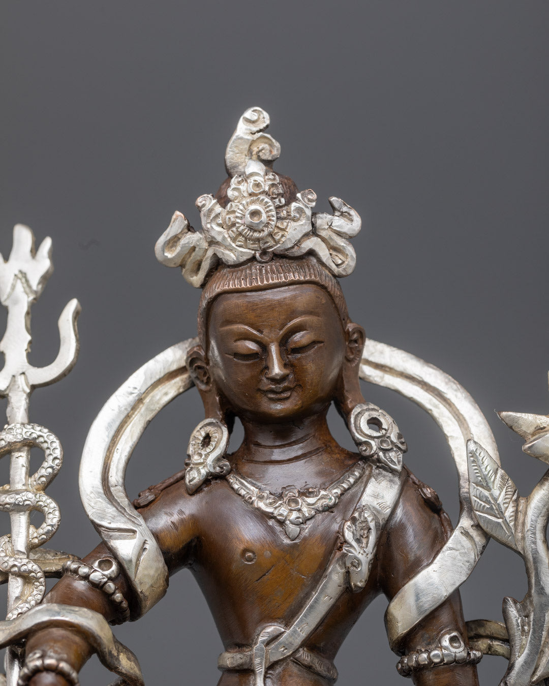 intricate details on the silver-plated face on a traditional Kurukulla deity statue.