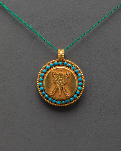Close-up of intricate shell design on gold-plated copper locket with stone details