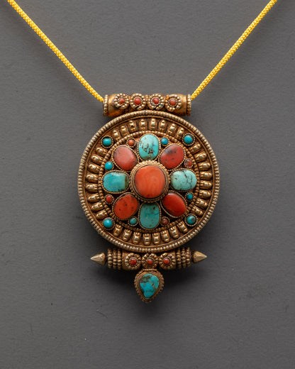 Close-up of intricately carved Himalayan amulet pendant showing detailed gold-gilded design
