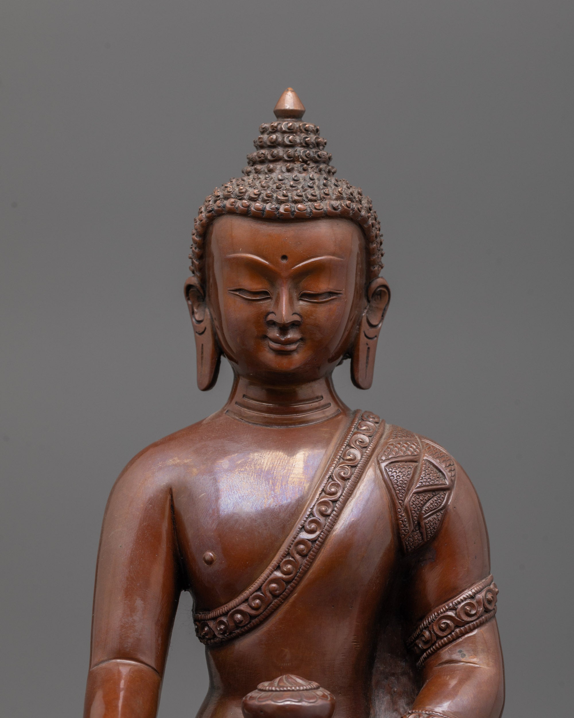 Close-up of oxidized copper Shakyamuni Buddha face with serene expression