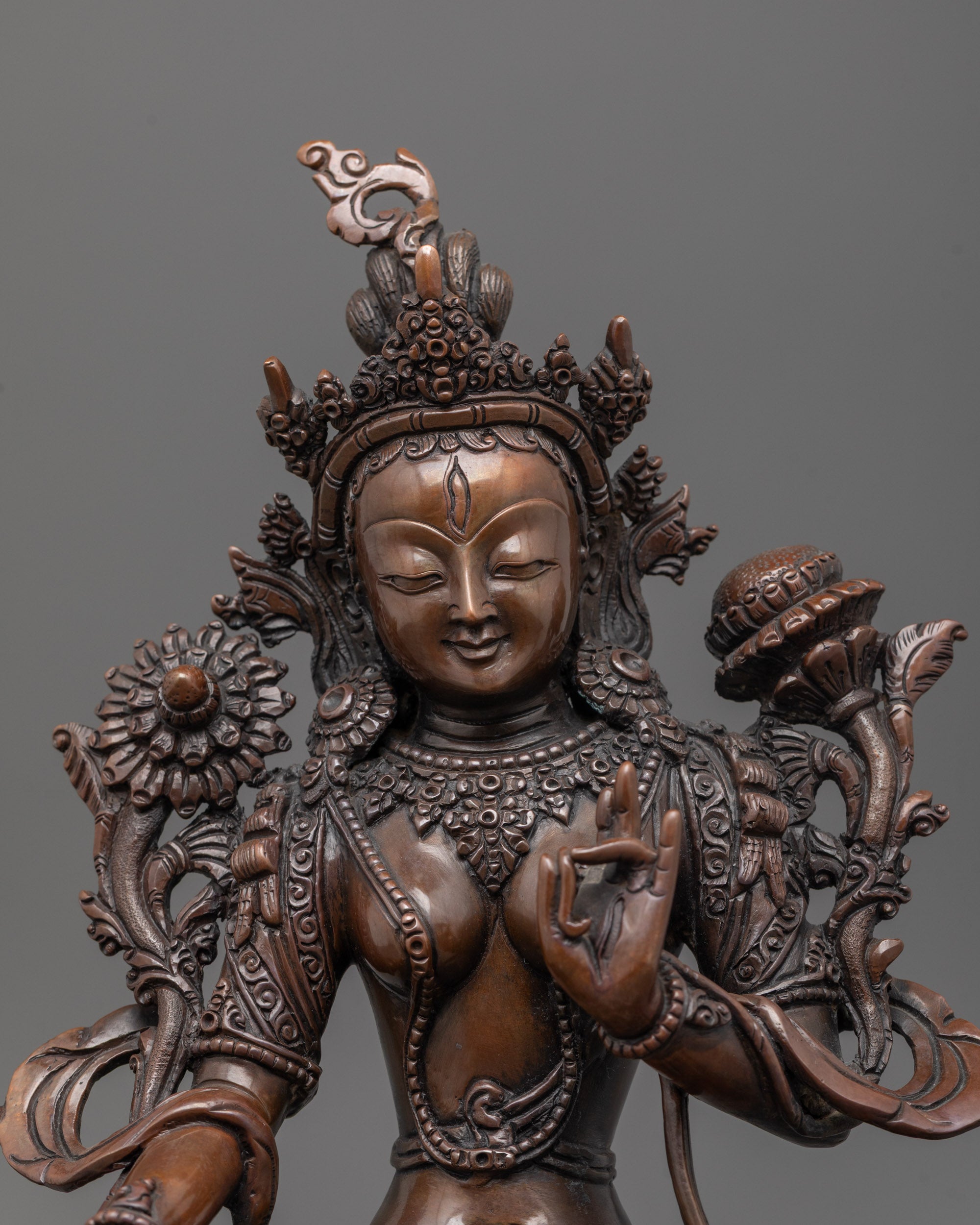 Close-up of oxidized copper White Tara statue showing intricate carved flowing robes detail