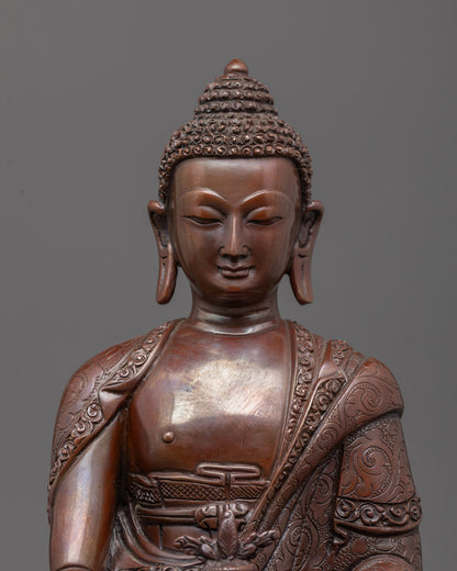 Close-up of oxidized copper face and intricate robe on Medicine Buddha statue
