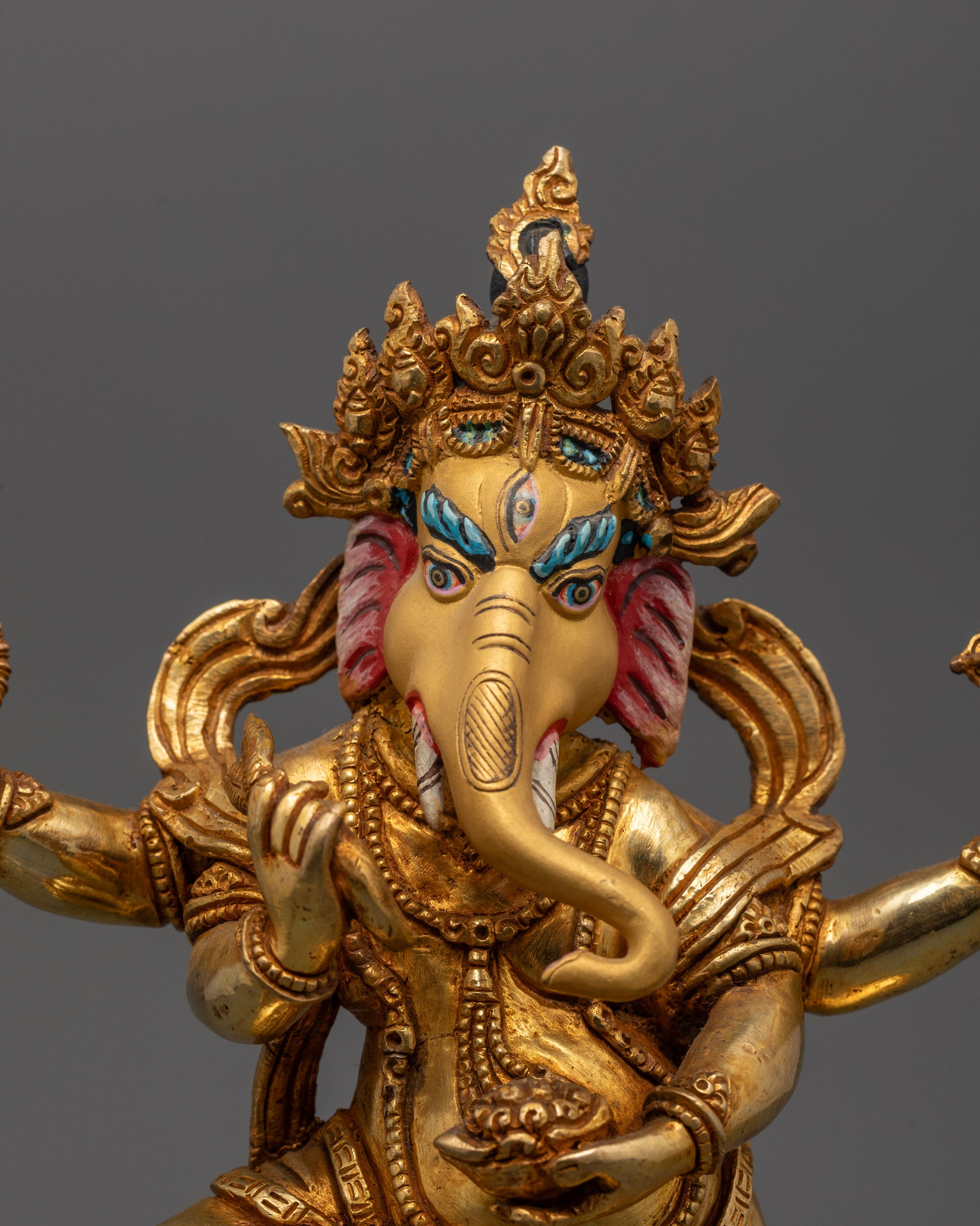 Close-up of radiant 24k gold polished face on traditional Nepalese Ganesh Statue