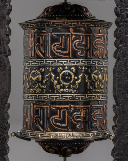 Close-up of sacred mantras on copper base of Tibetan prayer wheel with black acrylic paint