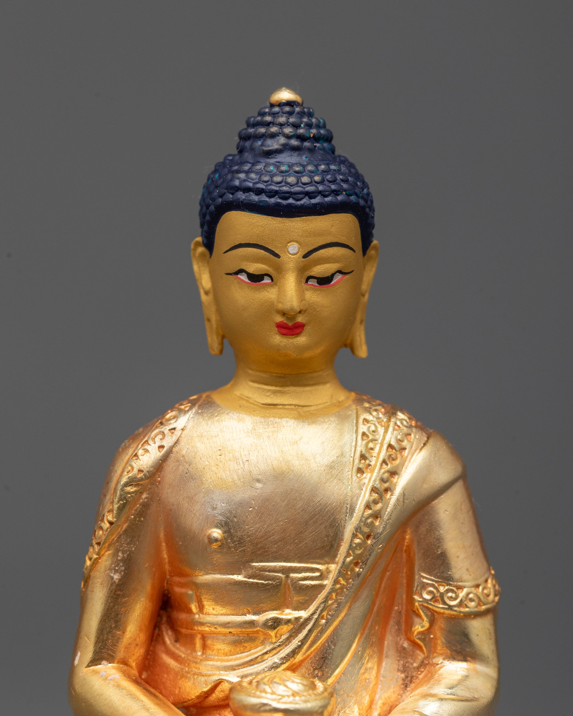 Close-up of serene Amitabha Buddha face with radiant 24k gold plating