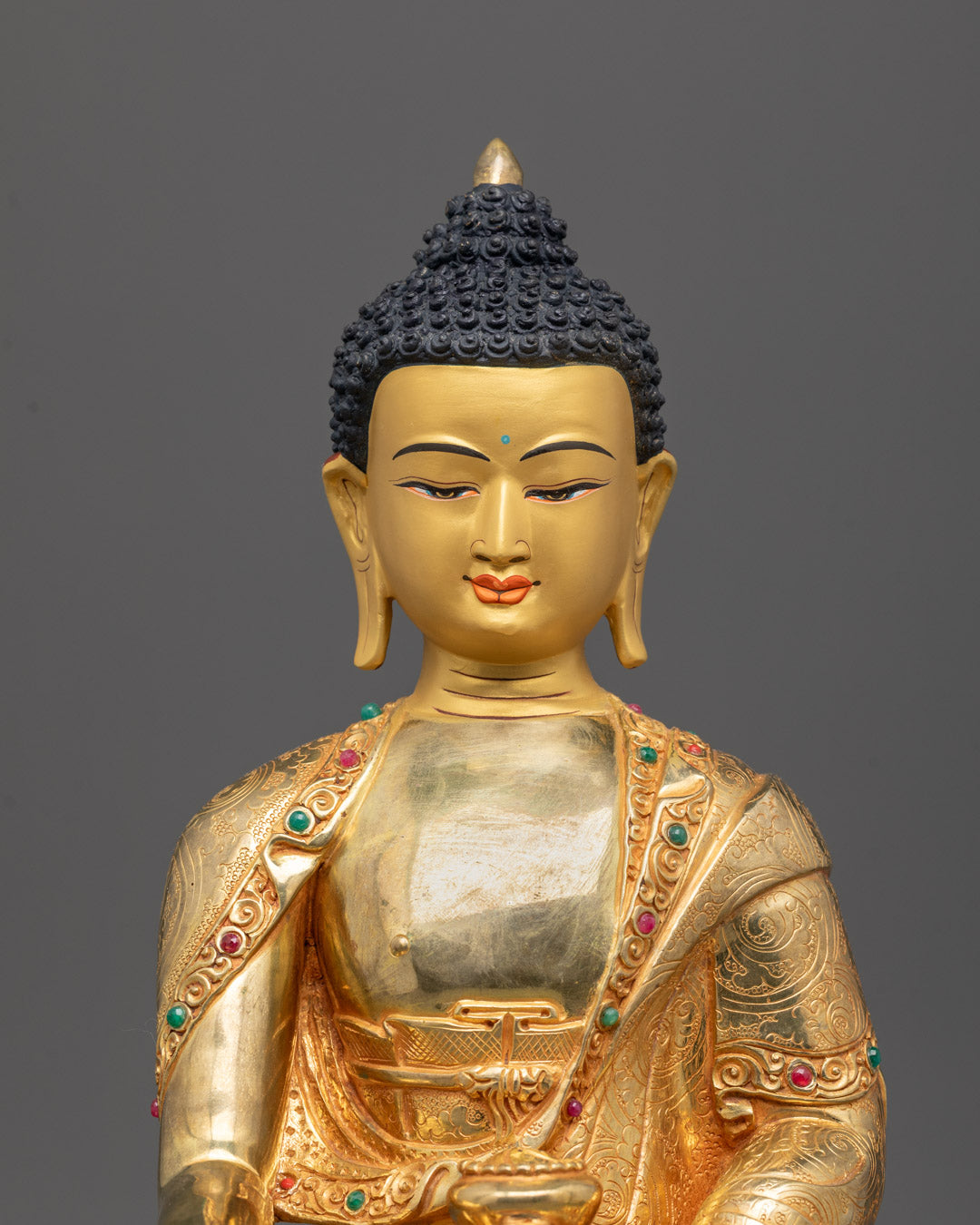 Close-up of serene Shakyamuni Buddha face and detailed gold-plated robes