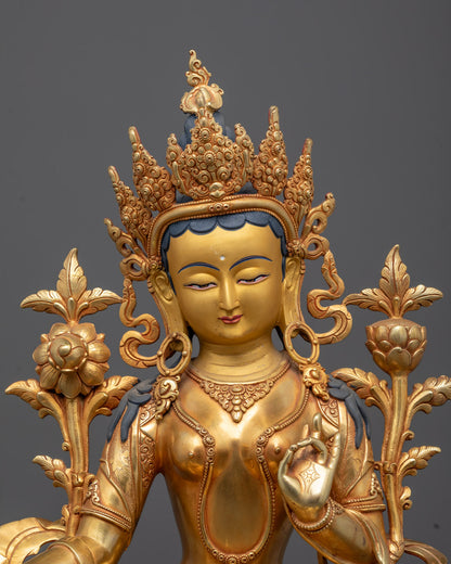 Close-up of serene gold-gilded face and ornate five-jeweled crown of Green Tara