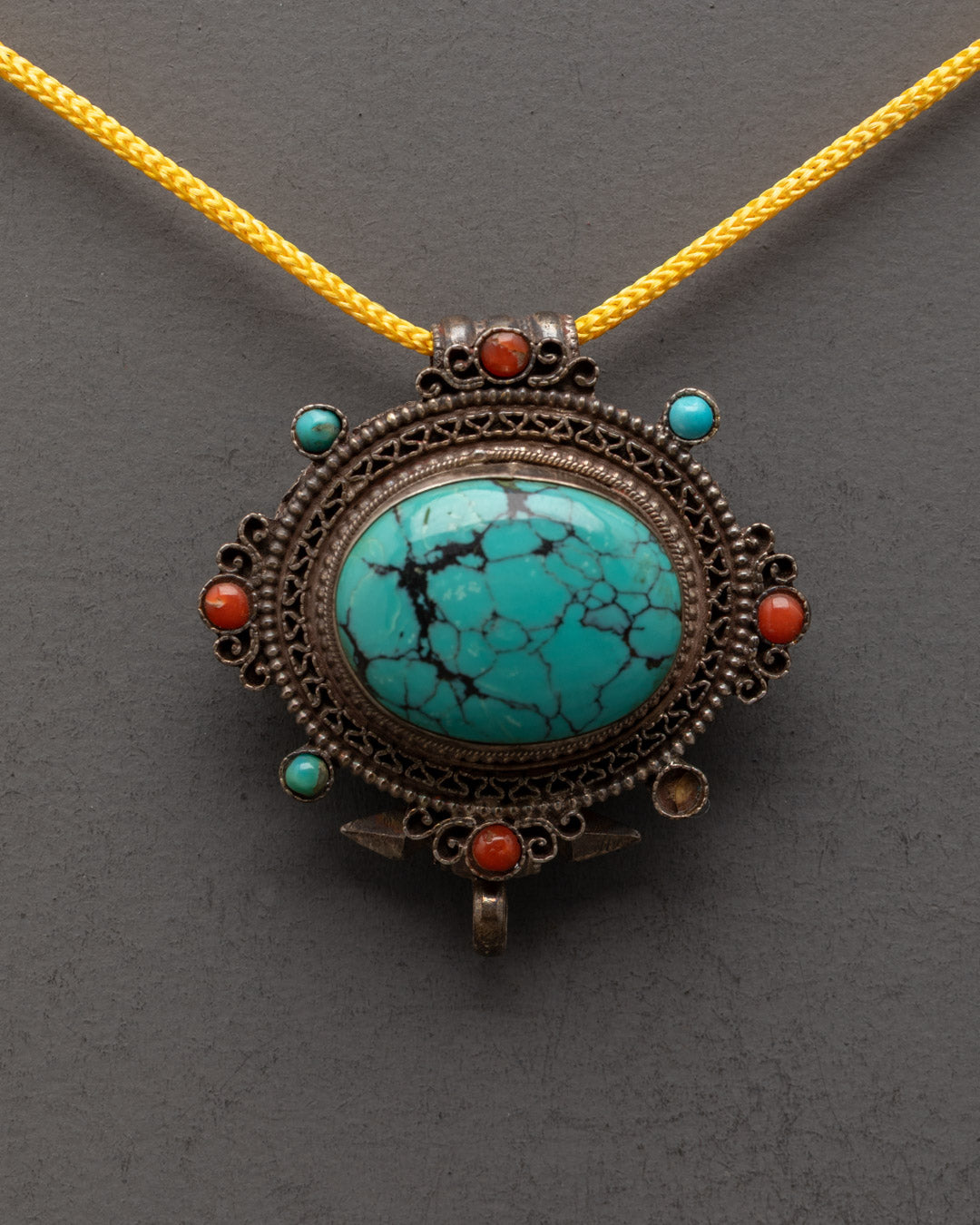 Close-up of turquoise centerpiece on handcrafted Tibetan copper locket pendant