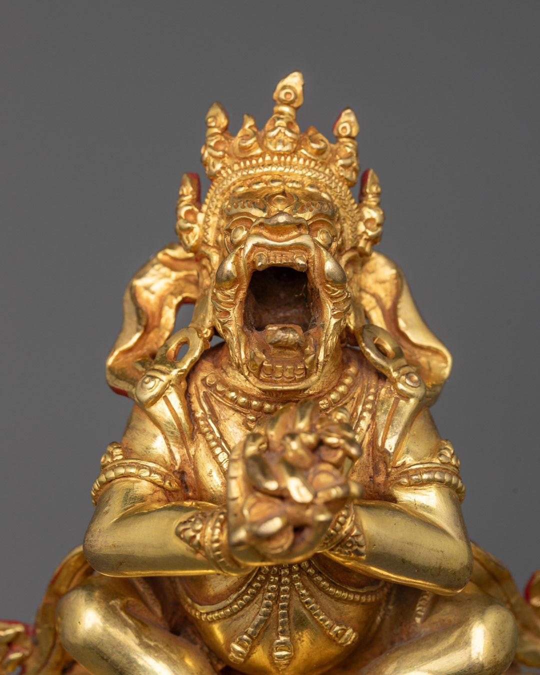 Close-up of wrathful gold-gilded face of Dorje Khadro Statue